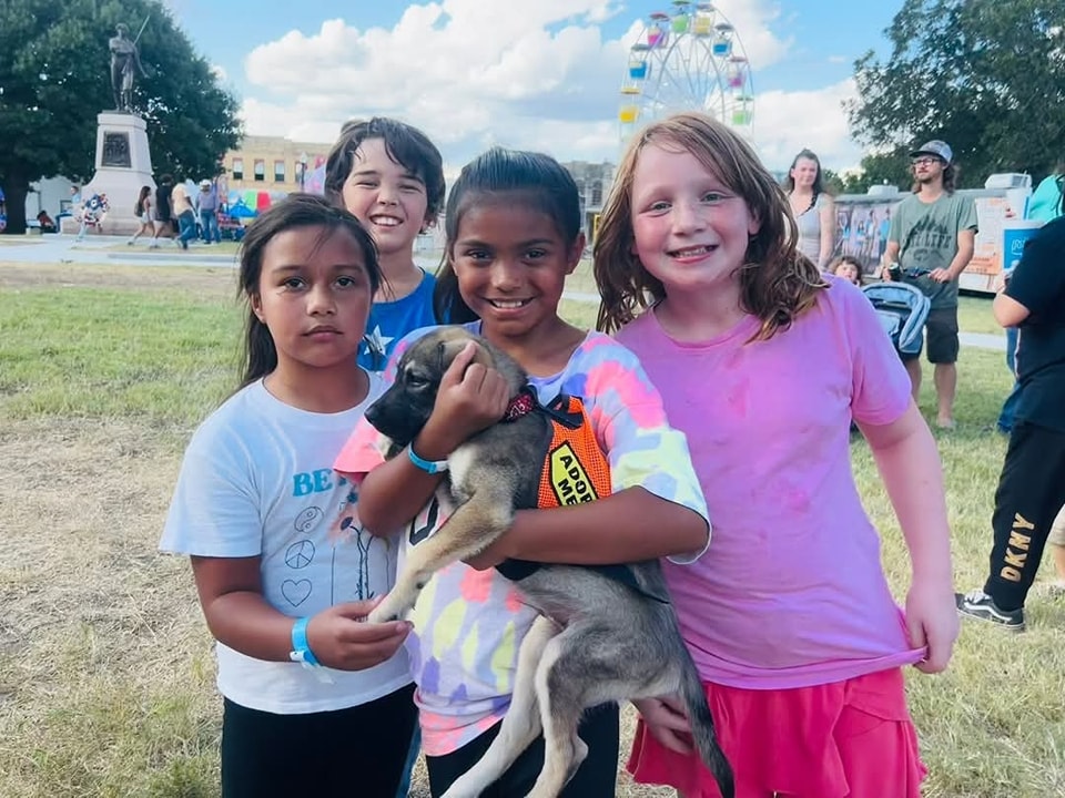 Kids holding puppy at fair